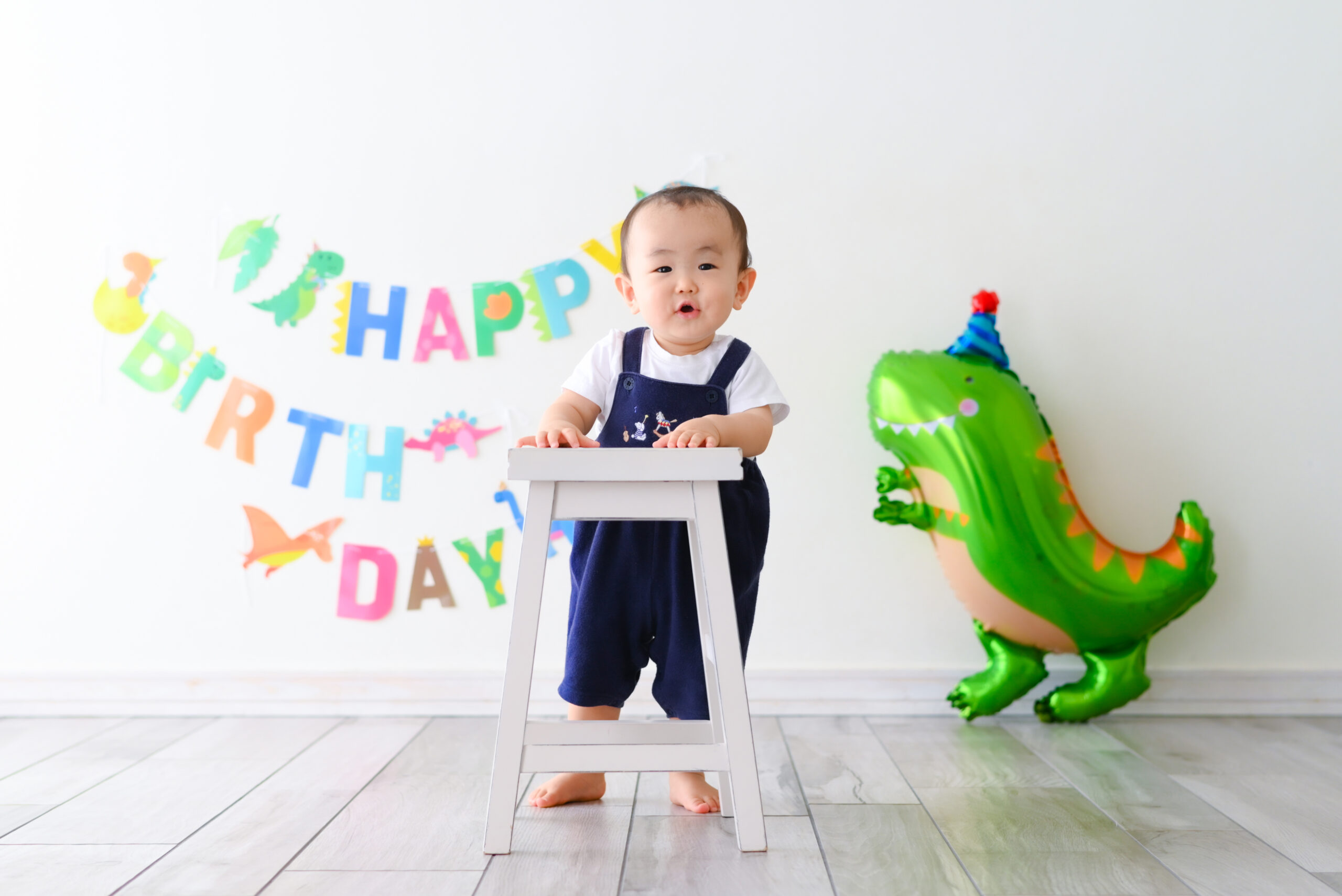 1歳お誕生日　撮影　つかまり立ちができるよ　恐竜の飾りつけがかわいい