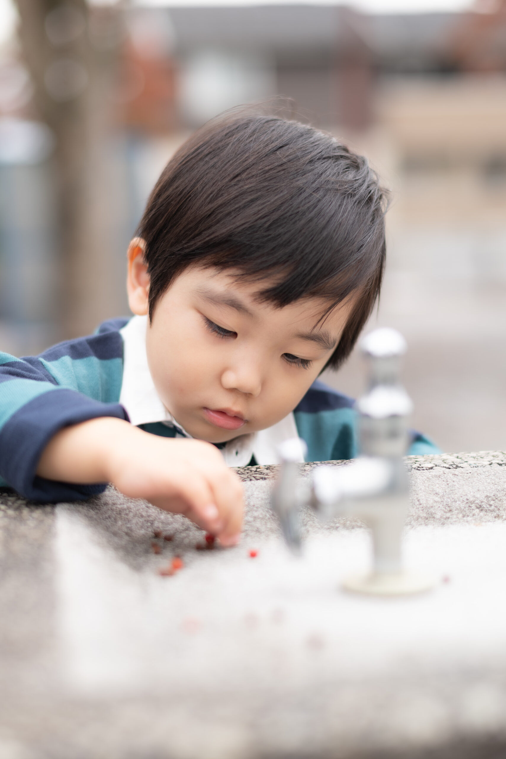 ３歳男児
公園の水飲み場に落ちてる赤い実を触っている写真