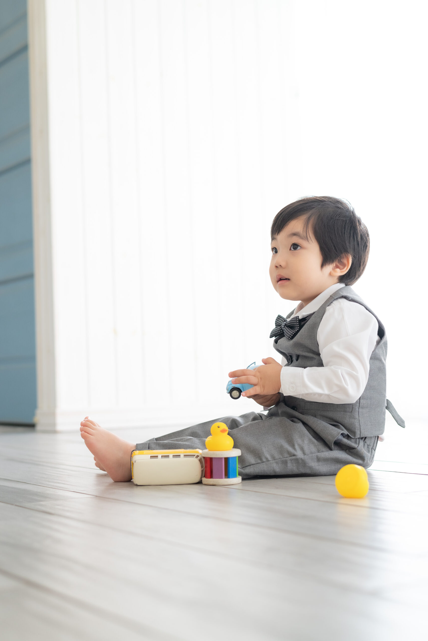 ３歳男児
黄色い車と青い車とお風呂用アヒルで座りながら遊んでいる写真