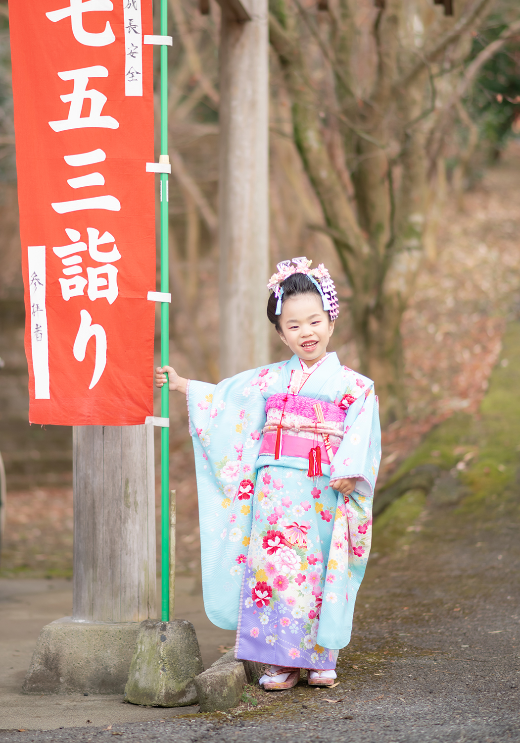 神社ロケ　七五三詣りの赤い旗と一緒に　7歳女の子